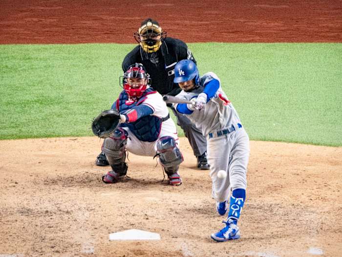 Oct 16, 2020; Arlington, Texas, USA; Los Angeles Dodgers right fielder Mookie Betts (50) singles and drives in a run against the Atlanta Braves during the seventh inning in game five of the 2020 NLCS at Globe Life Field.